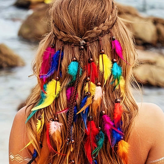 Woman wearing rainbow-colored hippie headband with vibrant feathers by the beach.