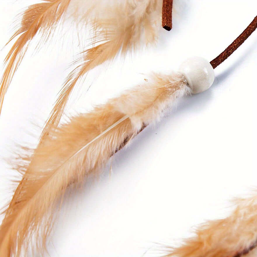 Close-up of a boho headband with faux feather tassels, featuring light brown feathers and a white bead, ideal for festivals and bohemian outfits.