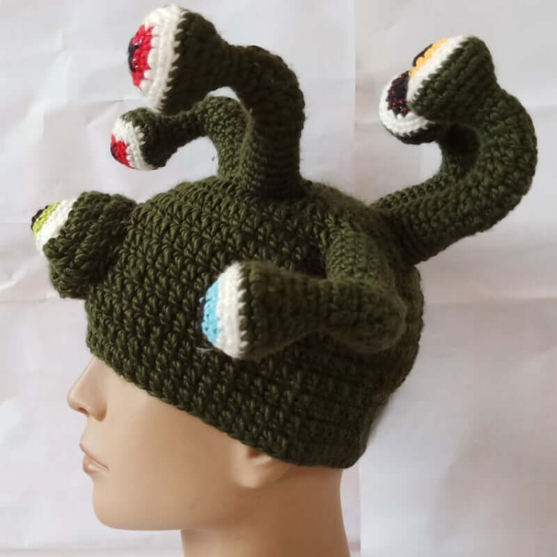 Handmade knitted monster hat with octopus eye design in green, ideal for festivals, cosplay, or quirky costume events.