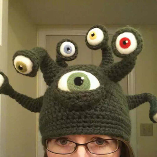 Handmade knitted hat with octopus eye design, perfect for festivals and costumes, worn by person with glasses.