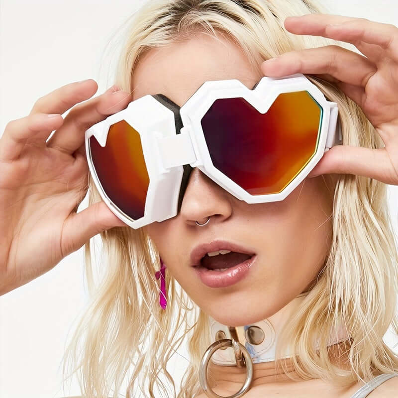 Stylish woman wearing oversized heart-shaped Y2K fashion glasses with mirrored lenses, perfect for rave parties and festivals.