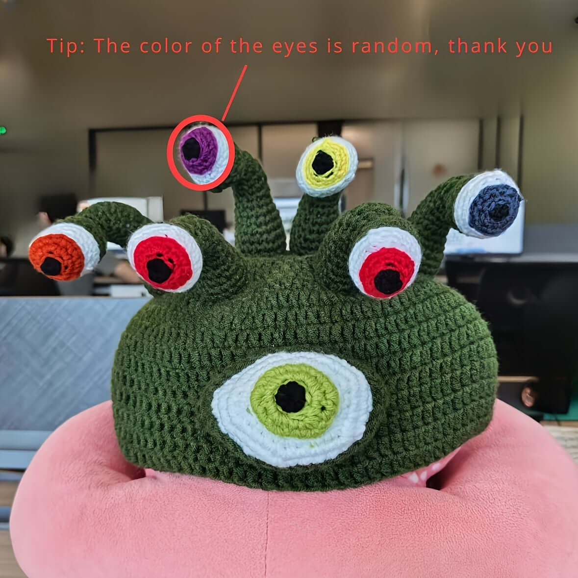 Handmade knitted green monster hat with random colorful eyes, perfect for festivals and costumes.