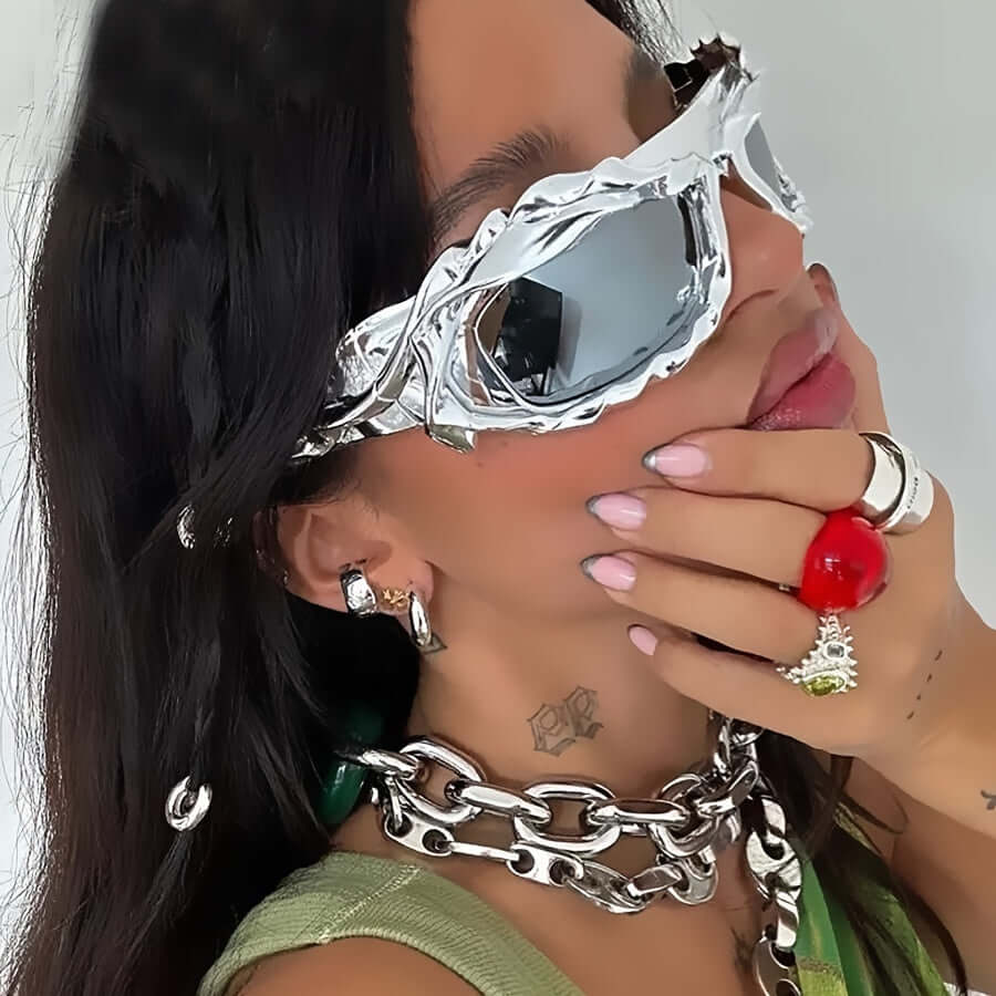 Woman wearing Y2K wrap-around punk sunglasses with mirrored lenses and bold accessories at a rave party.