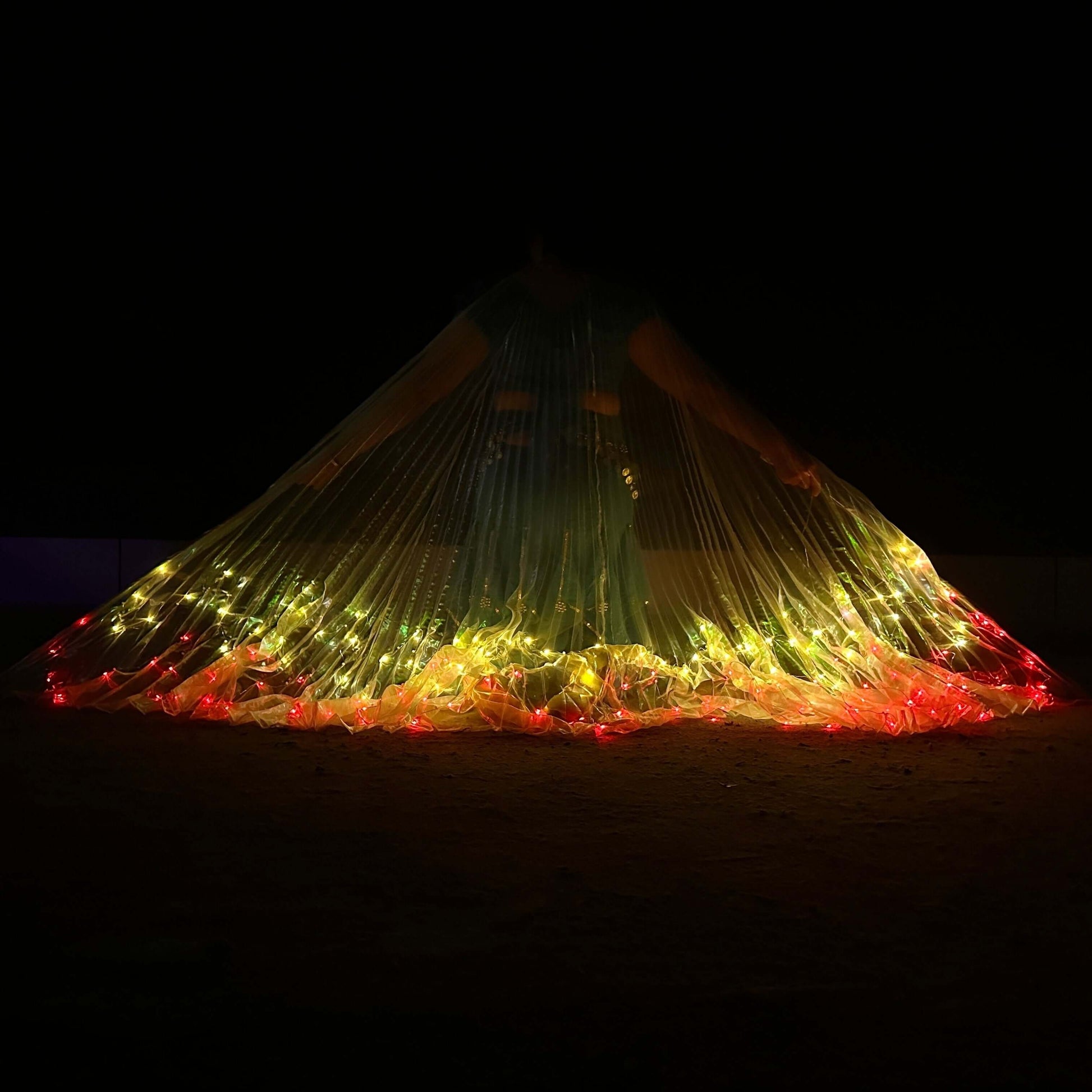 LED angel wings cape with red and yellow lights glowing in the dark, perfect for festival and stage performances.