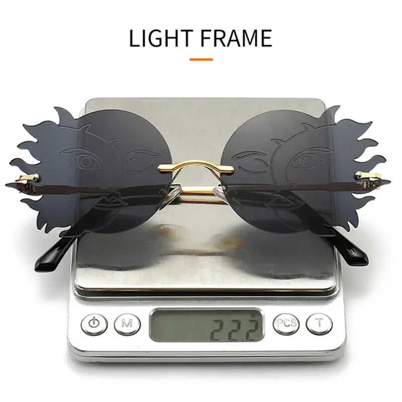 Stylish rimless round sunglasses with sunburst design on digital scale showing lightweight frame, emphasizing modern fashion aesthetics.