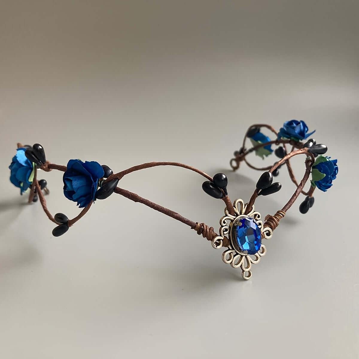 Handcrafted Medieval Witch Headband with blue gemstones and floral accents, perfect for rave and themed events.