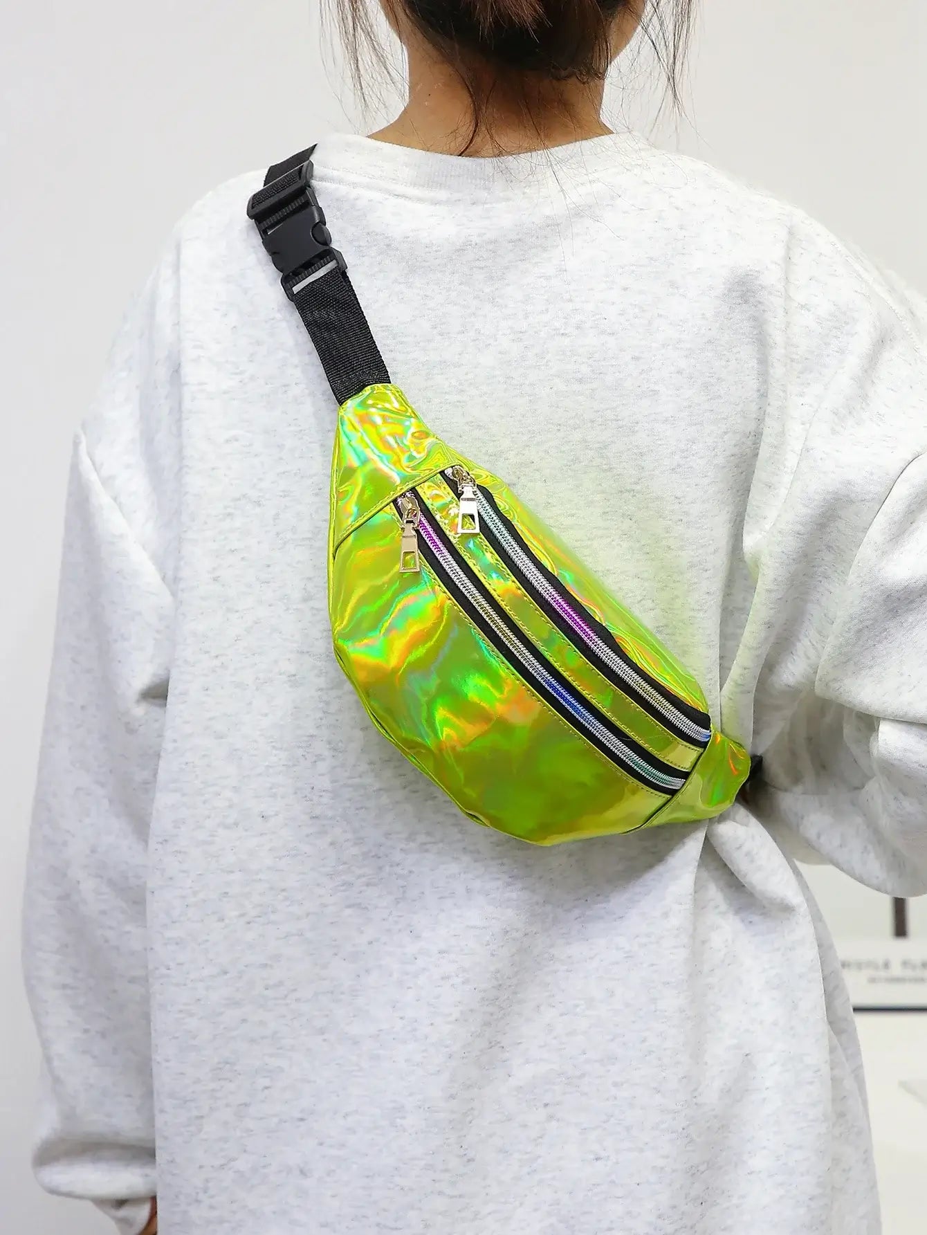 Unisex holographic waist bag in neon green worn across the shoulder, ideal for festivals and travel.