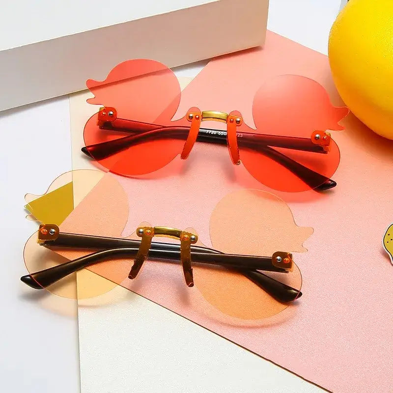 Duck-shaped rimless sunglasses with UV protection, ideal for festivals and rave parties, features bold design in vibrant colors.