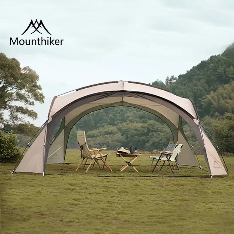 Foldable dome tent set up outdoors with chairs under it, showcasing its spacious design and sturdy structure for camping.