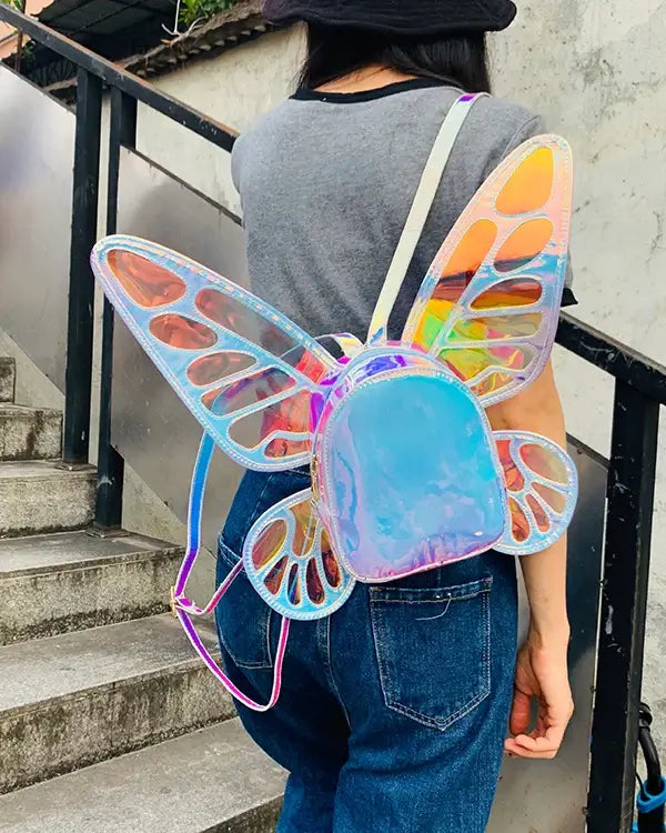 Person wearing a holographic butterfly wings mini backpack with reflective stripes, perfect for festivals and casual outings.