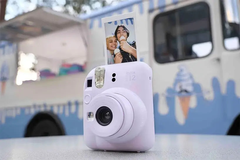 Lilac Purple Fujifilm Instax Mini 12 Instant Camera with selfie photo, perfect for capturing memories.