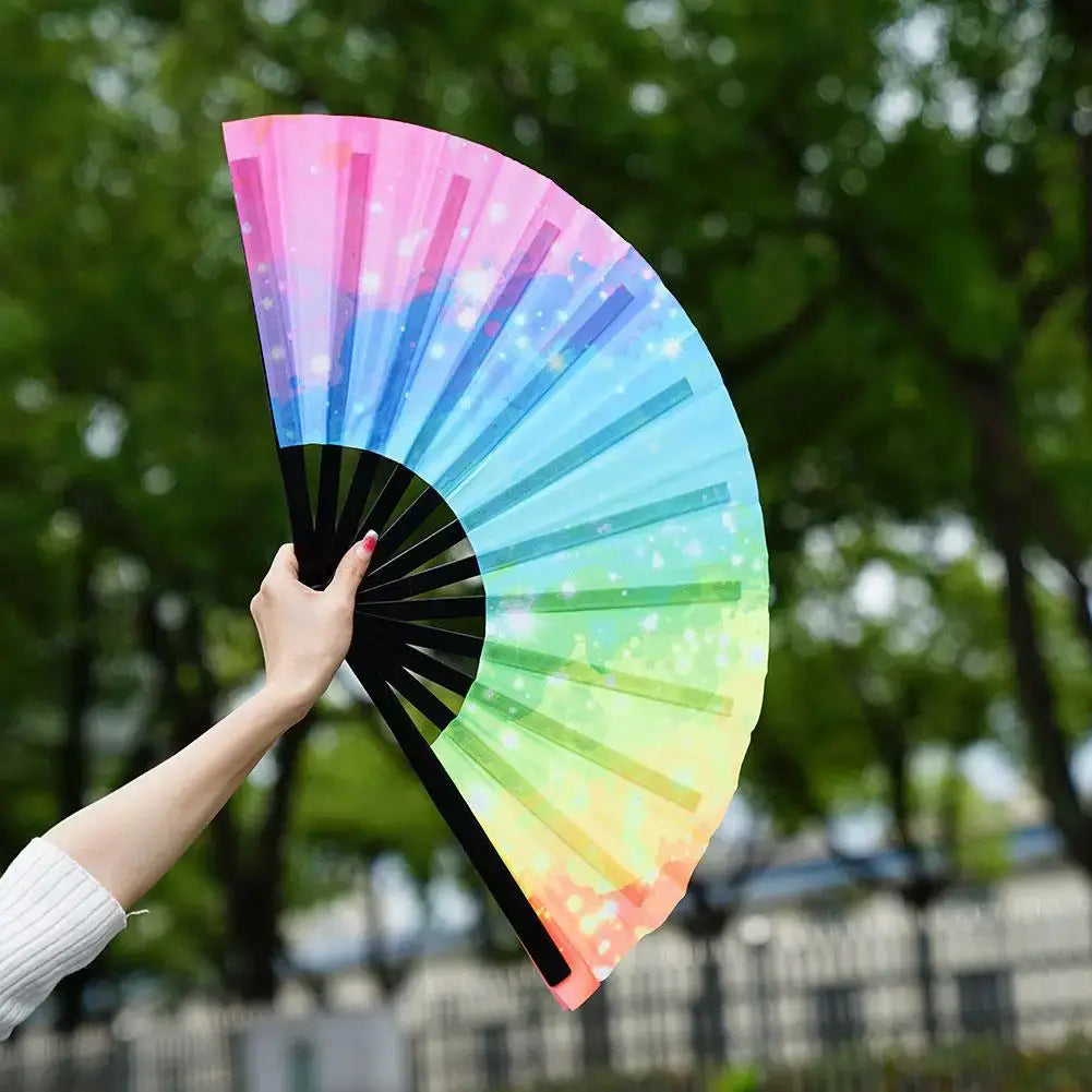 Colorful reflective rave fan with gradient design, held open outdoors, perfect for festivals and dance parties.