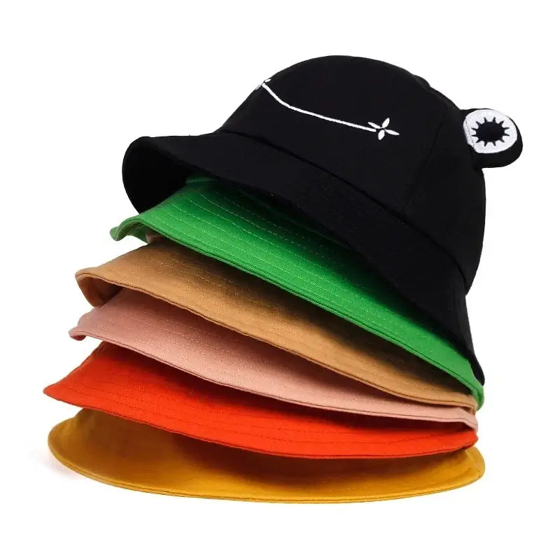 "Stack of colorful cute frog-themed bucket hats for summer sun protection, ideal for outdoor leisure activities."