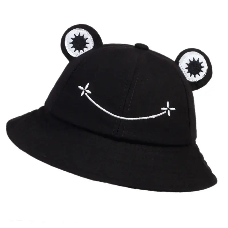 Black frog bucket hat with cute embroidered face and ears, offering sun protection and playful style for outdoor activities.