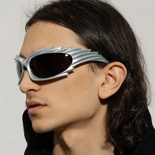 Stylish man wearing futuristic Y2K punk one-piece rave sunglasses with rimless design, showcasing edgy retro fashion.