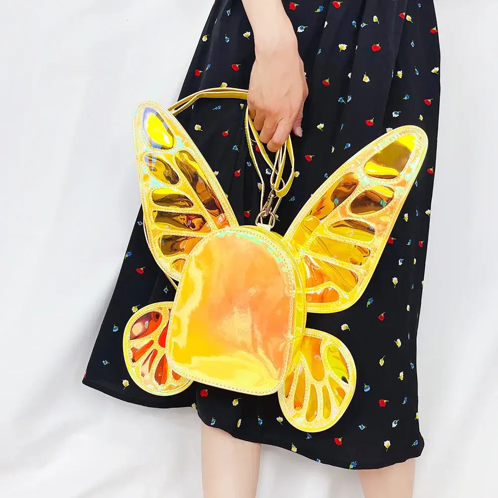 Woman holding a holographic butterfly wings mini backpack, ideal for festivals and parties, featuring vibrant reflective design.