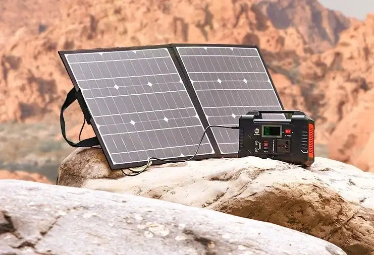 Portable 200W power station with solar panel set up on rocky terrain for outdoor camping and emergency power supply.