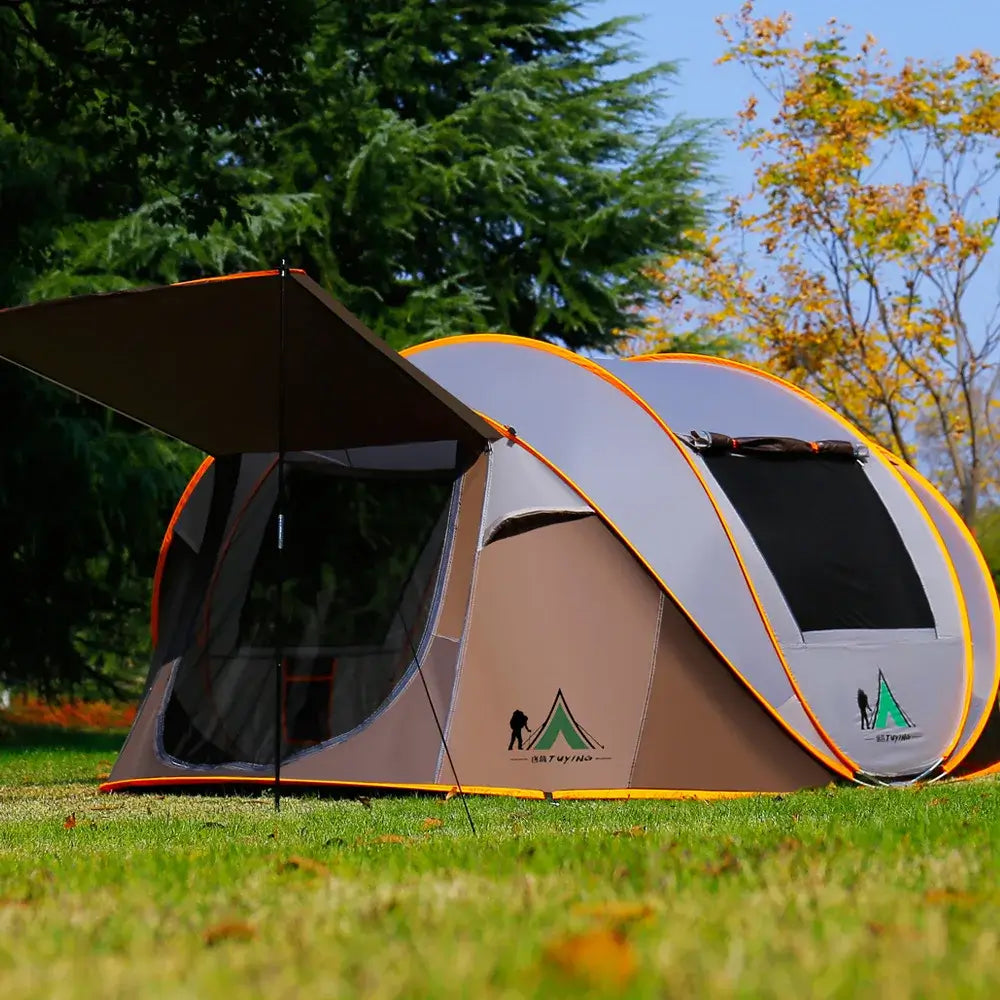 Ultralight automatic pop-up camping tent for 3-4 people, windproof and rainproof, set up in a grassy outdoor area.