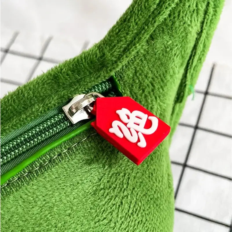 Green edamame-inspired shoulder bag with red zipper pull, perfect for festivals and parties.