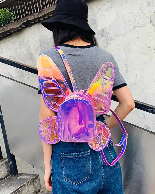 Woman wearing holographic butterfly wings mini backpack, perfect for festivals and casual outings. Reflective and eye-catching design.