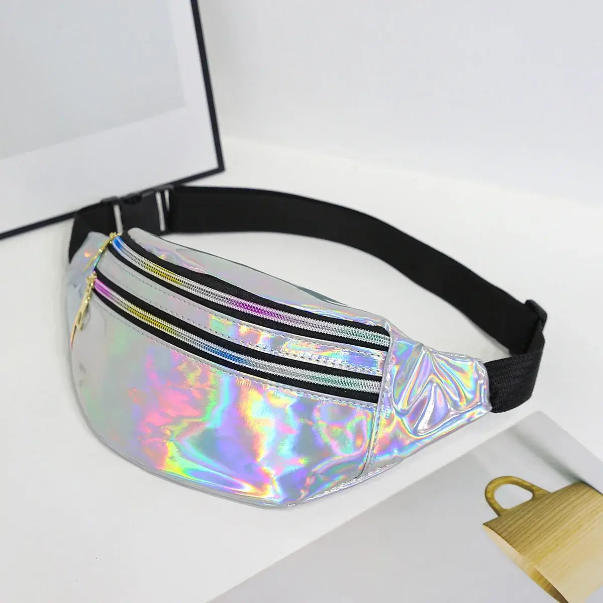 Unisex holographic laser waist bag, versatile for festivals and travel, shown in a reflective finish with black strap and zipper detail.