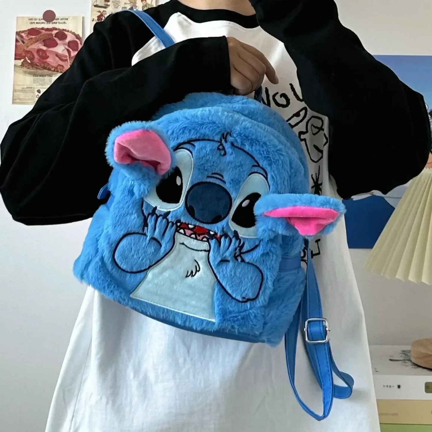 Child holding a blue cartoon Stitch kids mini backpack with pink ears, featuring a soft handle and zip closure, ideal for festivals.