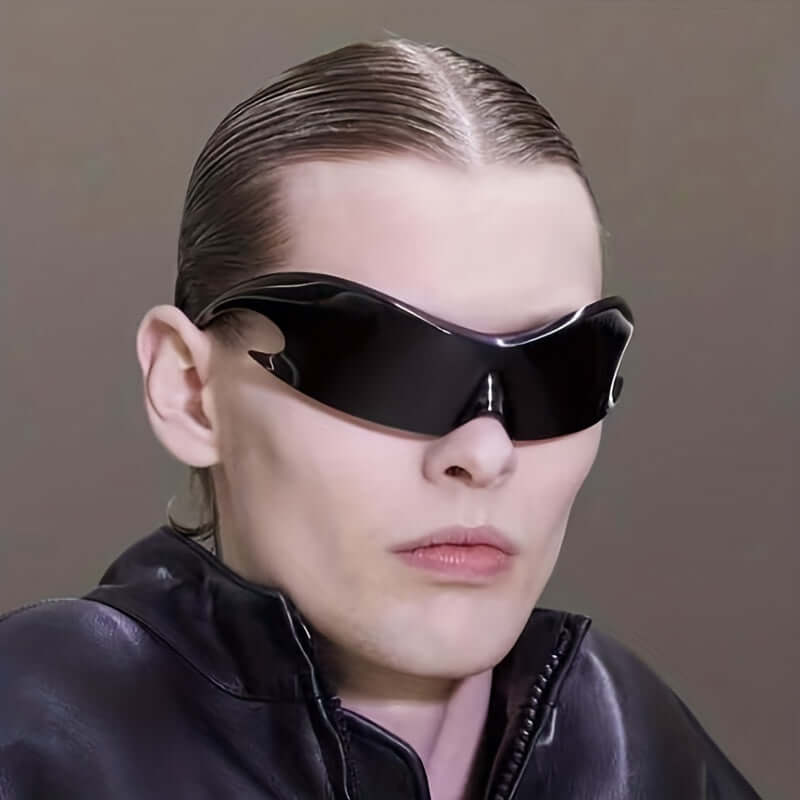 Trendy oversized Y2K rave sunglasses with a sleek one-piece design, worn by a person in a stylish black outfit.