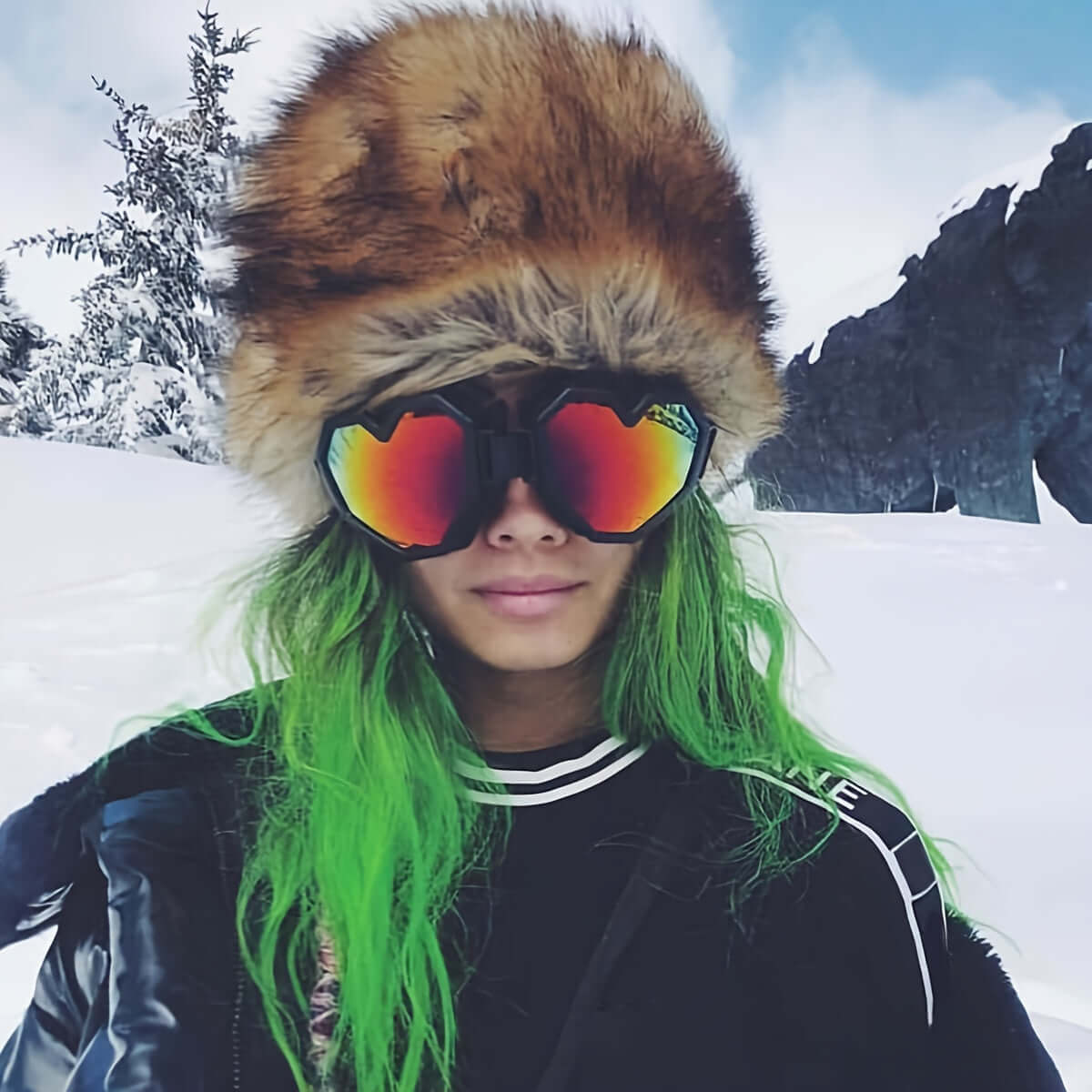 Person wearing heart-shaped mirrored glasses and fur hat in snowy outdoor setting