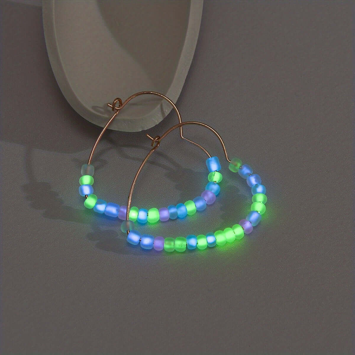 Glow-in-the-dark acrylic hoop earrings with vibrant beads, perfect for music festivals and night parties.