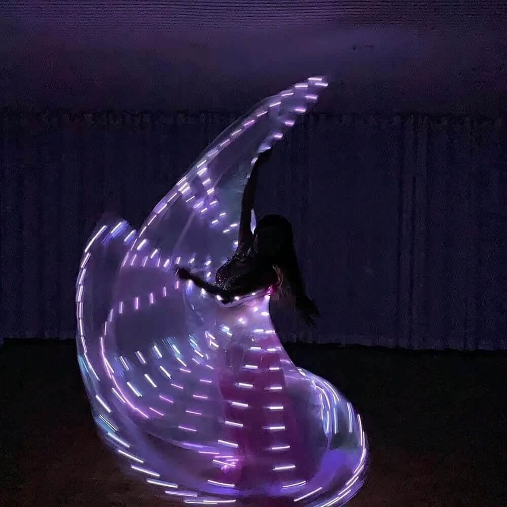 LED butterfly wings with cool white lights creating a mesmerizing effect during a dance performance at night.