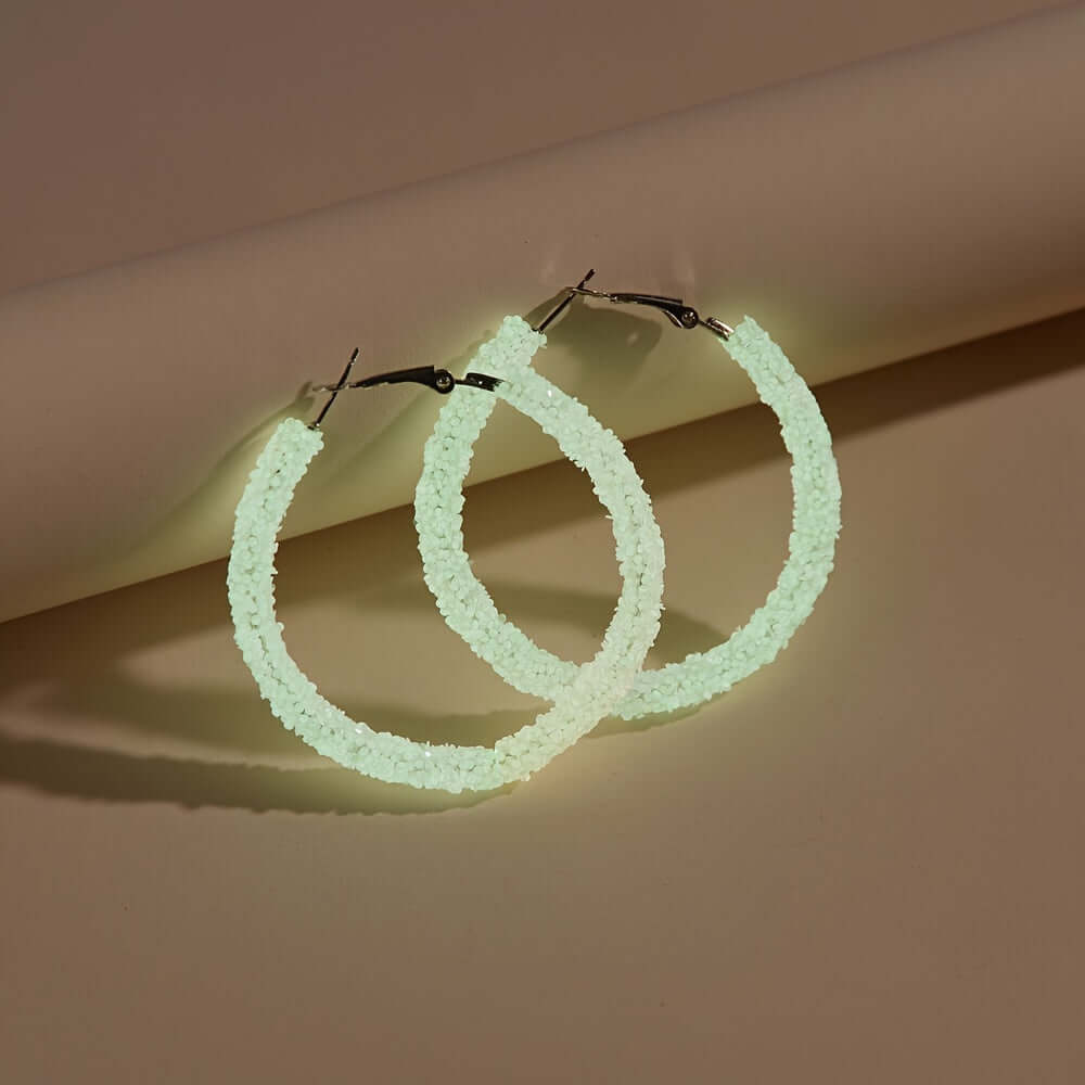 Glow-in-the-dark acrylic hoop earrings set, perfect for parties and festivals, displayed on a neutral background.