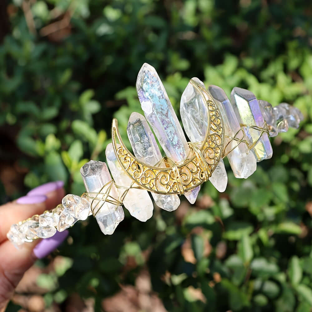 Elegant crystal headband with moon-shaped design, perfect for weddings and special occasions, held outdoors with greenery background.