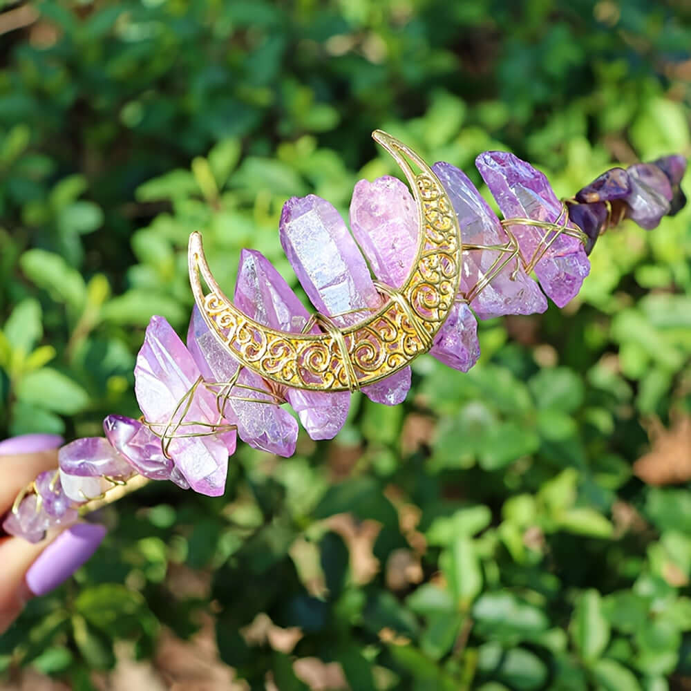 Elegant moon-shaped crystal headband with purple stones, perfect for weddings and special occasions, displayed in a garden setting.